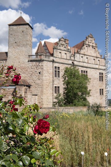 Burg Cadolzburg, Blick von Süden auf Burg mit dem Burggarten, blühende Rosen, Sommer